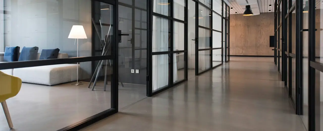 Pasillo acristalado de una oficina moderna con salas de reunión a ambos lados