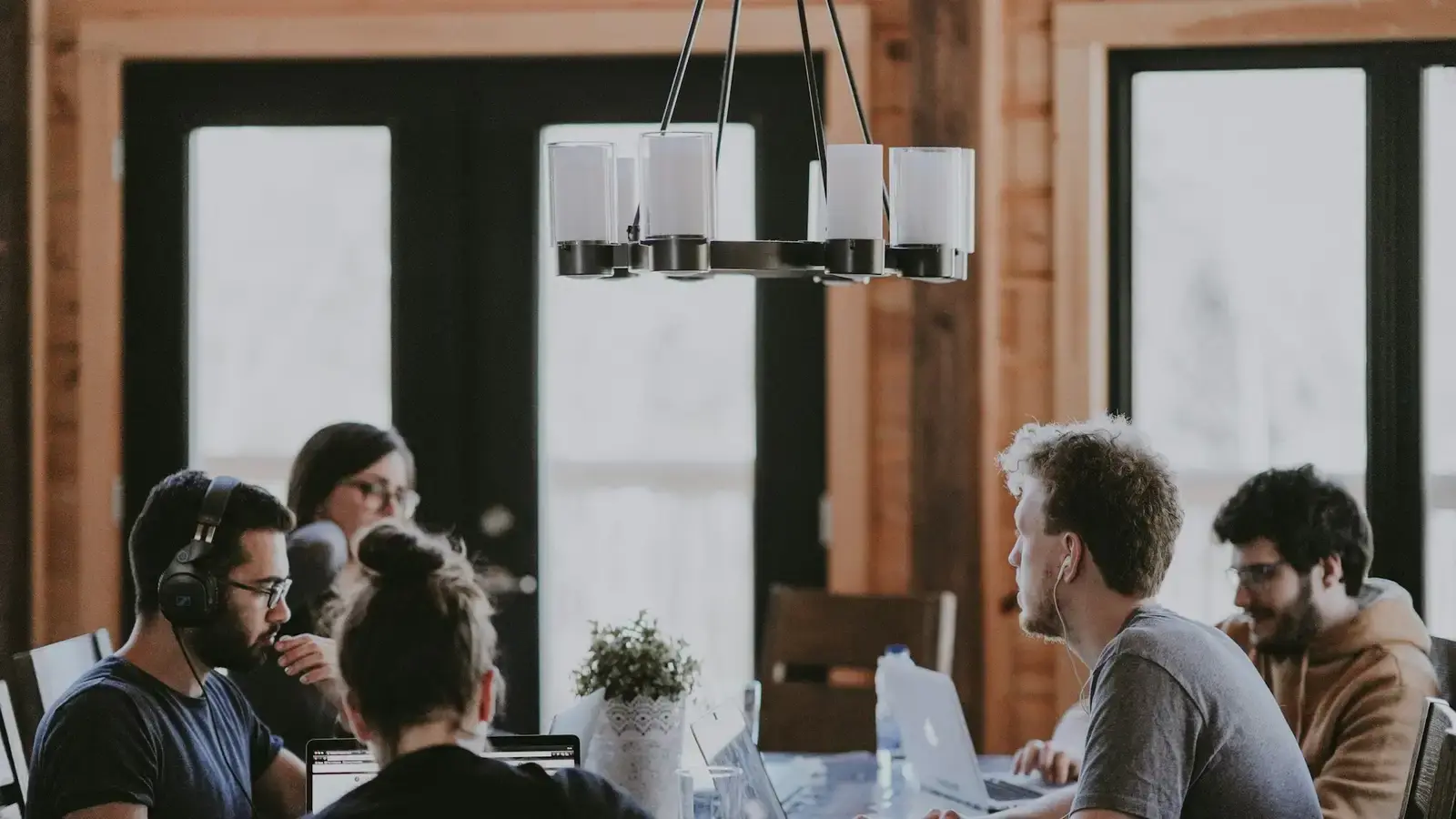 Equipo de trabajo reunido alrededor de una mesa siguiendo una explicación en pantalla