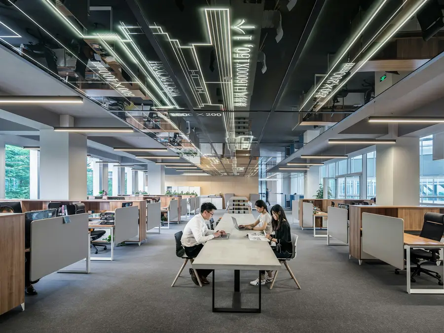 Oficina diáfana con puestos de trabajo ocupados vista desde una planta superior